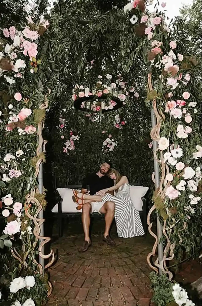 Taylor Swift and Travis Kelce in the floral setting shown in their engagement photographs